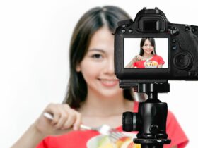Asian food vlogger with fruit salad behind camera, social media production concept