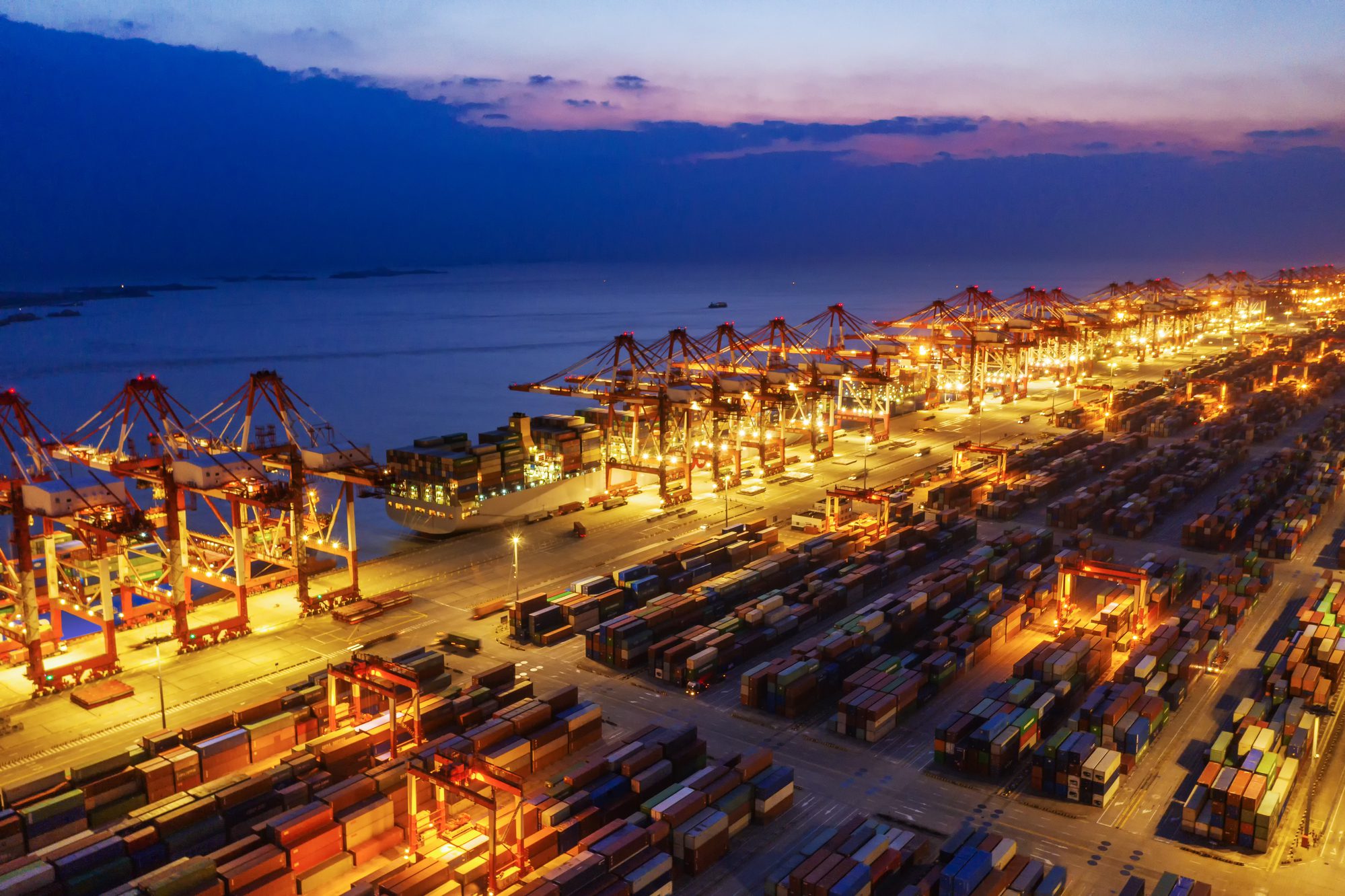 Container ship in export and import business and logistics. Shipping cargo to harbor by crane. Water transport International. Aerial view