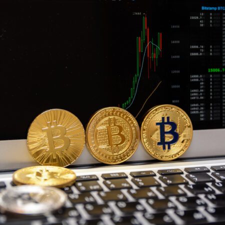 golden bitcoins and chart on monitor