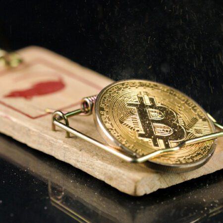 Bitcoin coin falling on a mouse trap. Naive investment concept and losing money